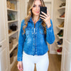 Close-up front view of women’s blue denim shirt by 3D Denim with metal front buttons, chest pockets and slim tailored fit