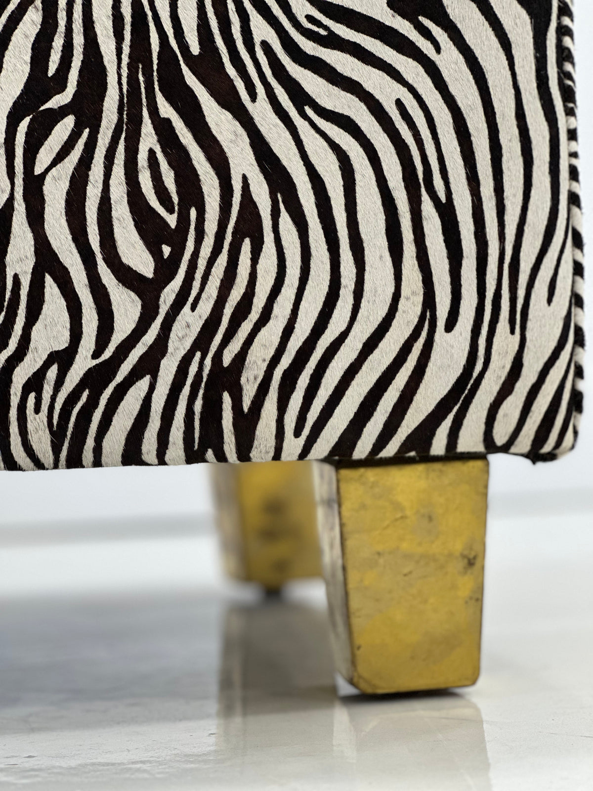 Close-up of brass-covered stool legs on white background