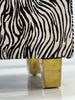 Close-up of brass-covered stool legs on white background