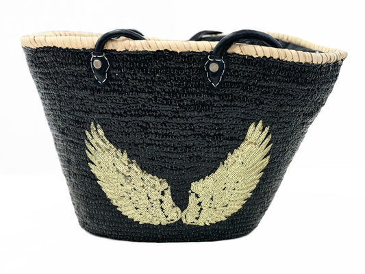 Large handmade black raffia beach and shopping basket with sparkling black sequins and gold angel wings, leather handles and drawstring liner, front view on white background, available at VVC Shop Sitia, Crete.
