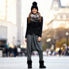 Woman in stylish outfit with black jacket, gray pants, and black boots standing in an urban setting.