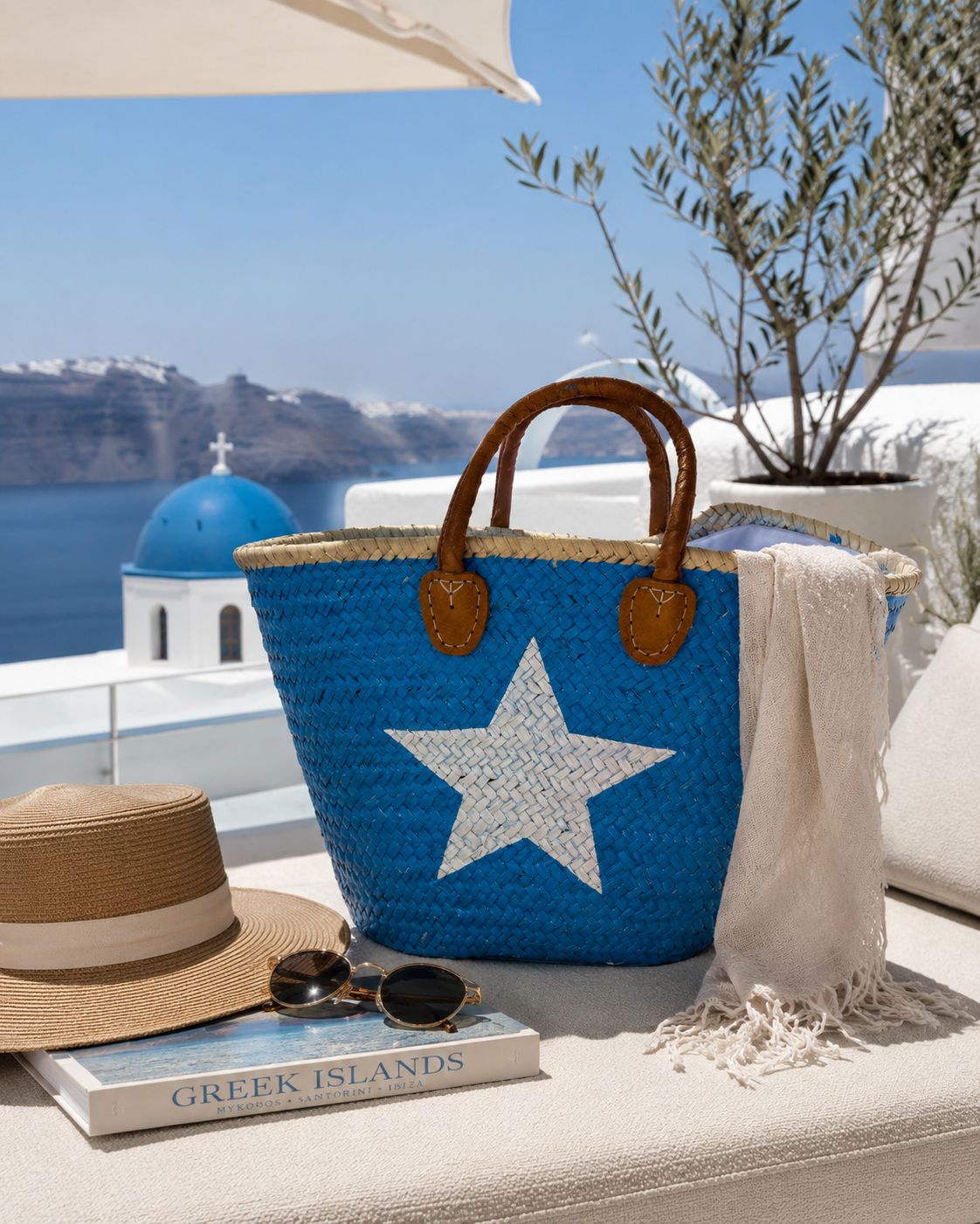 VVC turquoise beach basket with white star design styled with a blonde woman in white linen fashion on a Greek island holiday in Santorini.