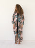 Woman wearing a long pink animal print Italian silk kimono by VVC, styled as an elegant evening outfit, front view.