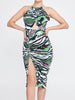 A midi dress featuring an off-the-shoulder design with a curb chain collar and a colorful animal print mix of leopard and zebra in green. The dress has a figure-hugging fit and a hidden central zipper at the back.