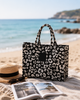 Black and white animal print Greenwich Polo Club beach bag on Mediterranean beach in Sitia Crete, stylish jacquard tote for holidays and summer travel