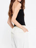 Side view of the Berrin black bandeau bustier styled with white trousers.