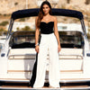 Woman wearing the Berrin black strapless bandeau bustier with white wide-leg trousers for a summer event in Sitia, Crete.