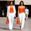 Berrin orange bandeau bustier top styled with white trousers, versatile women’s outfit for summer business and holidays in Crete