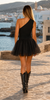 Back view of a black asymmetric one-shoulder top styled with a short A-line tulle skirt and cowboy boots in Crete, Greece.