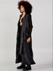 Side view of a women’s black long cardigan vest with adjustable straps and flowing asymmetric length at VVC SHOP Sitia