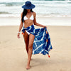 Front view of a blue and white batik scarf with orange fringes styled as a beach pareo VVC in Sitia, Crete.