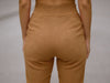 Close-up back view of camel brown slim fit wool trousers highlighting elastic waistband