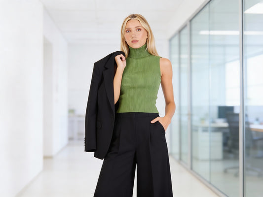 Warm green sleeveless A-line turtleneck knit top by Cherry Blue, styled with black trousers and blazer for modern office wear.