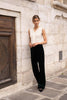 Choklate Paris sleeveless lace top in white, styled as a modern suit addition with black trousers for feminine office and evening wear.