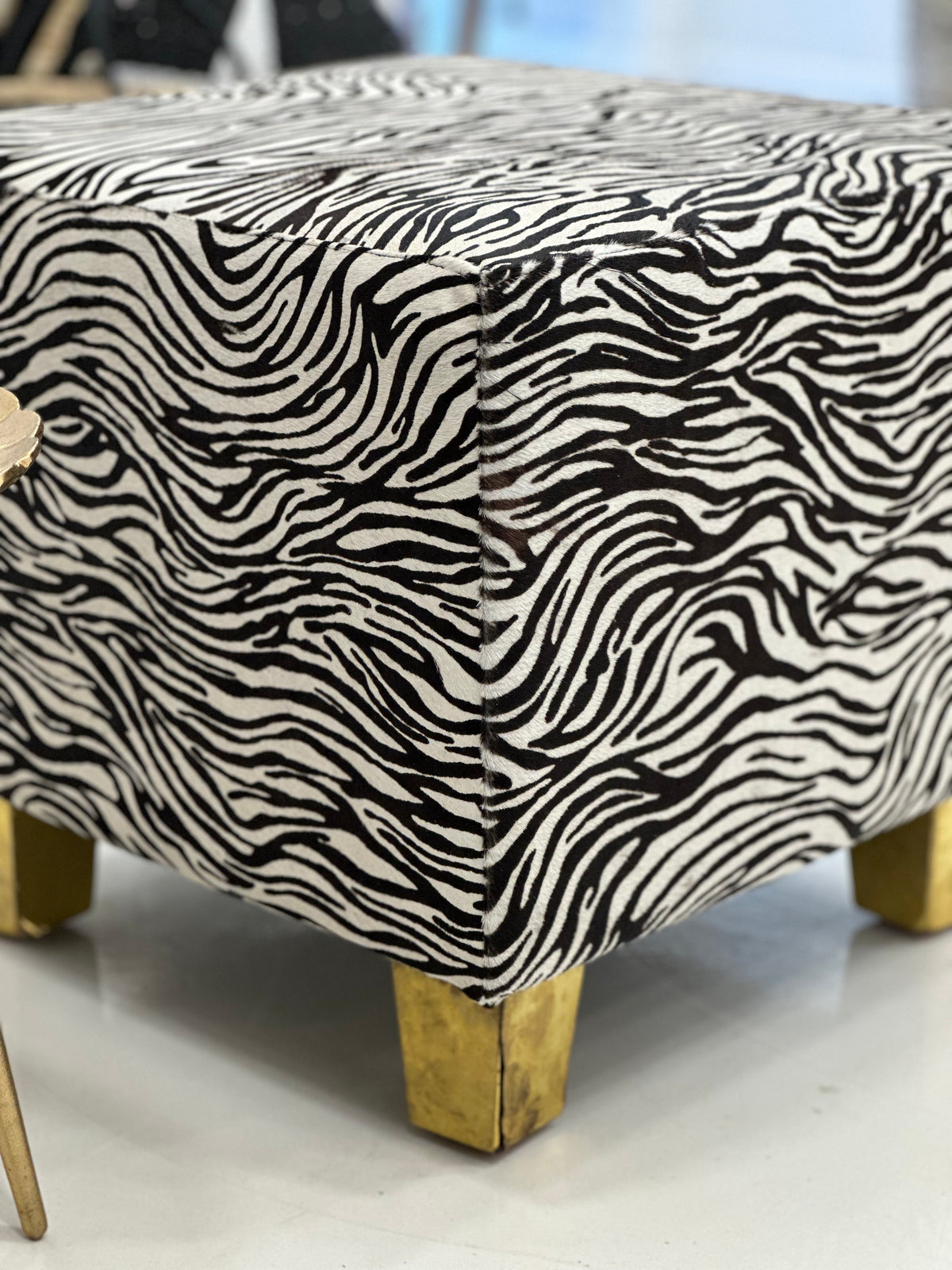 Macro shot of cowhide texture and brass leg connection detail on white background