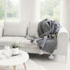 Soft cotton blanket in GRAY WITH WHITE POMPOM draped over a chair — big sale, last pieces at VVC SHOP SITIA