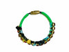 Green circular bracelet with black and gold-tone details photographed on a white background for VVC SHOP Sitia, Crete.