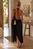 Handmade black fringe shoulder bag by VVC with extra long satin fringes, worn in boho resort style in Sitia Crete