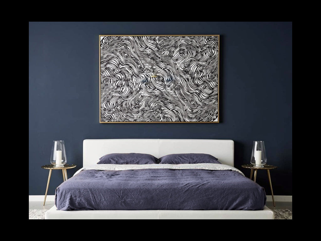 Gold Lilly gold water-lily-leaf side table with three legs beside a bed in a blue and white bedroom.