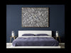 Gold Lilly gold water-lily-leaf side table with three legs beside a bed in a blue and white bedroom.