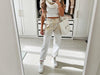 Front view of gold and white laminated shimmer trousers with relaxed tapered fit, rolled ankle cuffs and adjustable waist belt