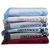 Folded Greenwich Polo Club beach towels with woven logo bands in assorted colours.
