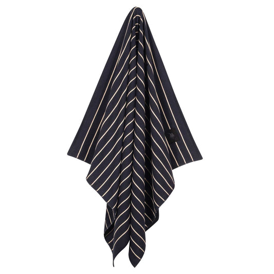 Hanging Greenwich Polo Club 4077 black cotton beach towel with fine beige stripes and fringed ends.