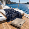 Greenwich Polo Club 4078 beige cotton jacquard beach towel with fine black stripes, styled on a resort sunbed.