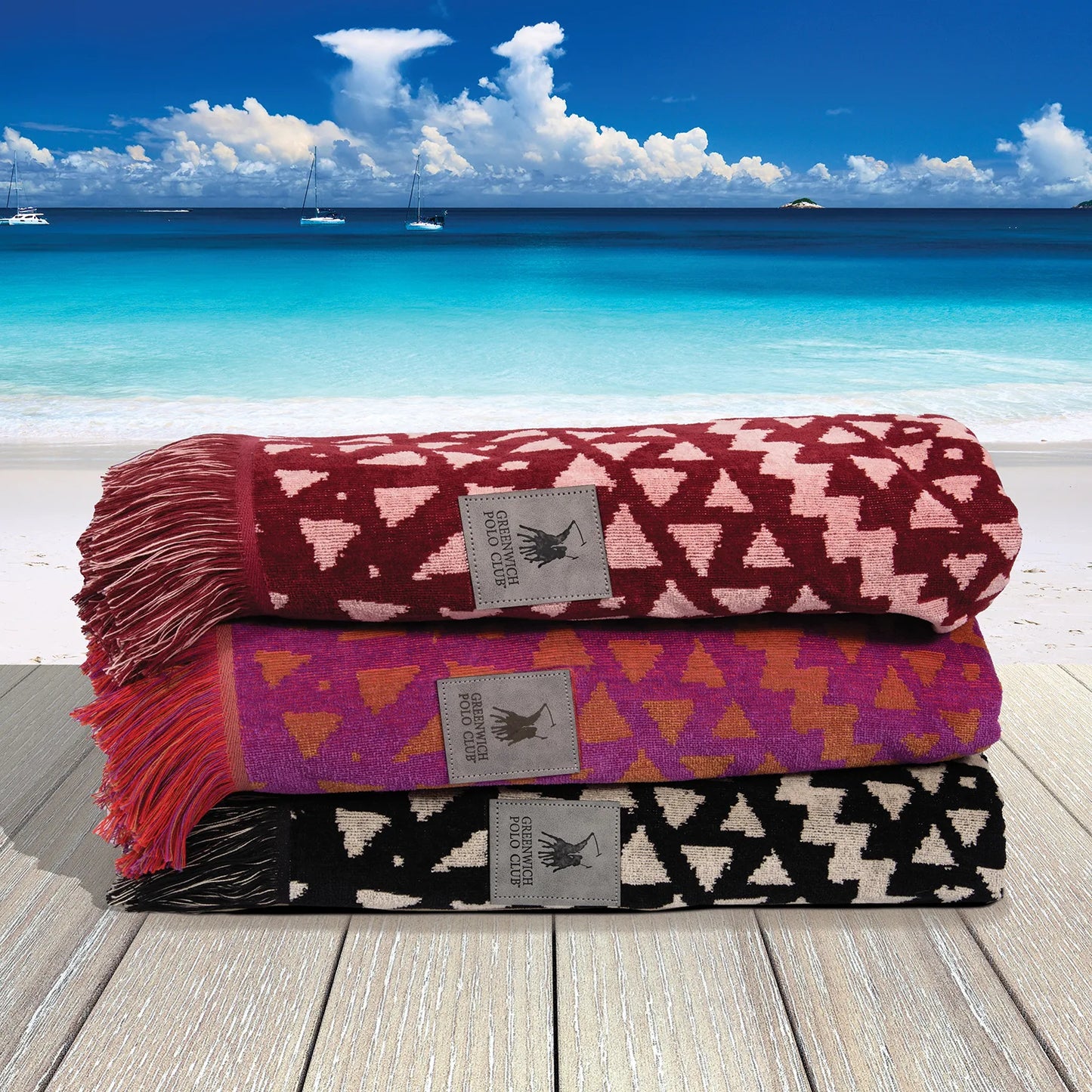 Folded Greenwich Polo Club ethnic-pattern beach towels in burgundy, grey and black colour options.
