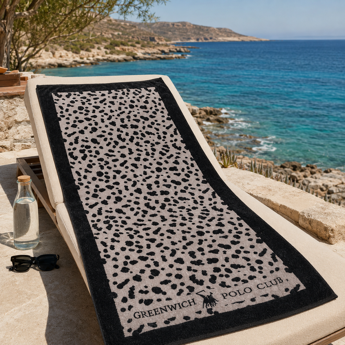 Greenwich Polo Club microfiber beach towel 5205 with black and grey animal print, displayed on a seaside sunbed in Crete.