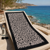 Greenwich Polo Club microfiber beach towel 5205 with black and grey animal print, displayed on a seaside sunbed in Crete.