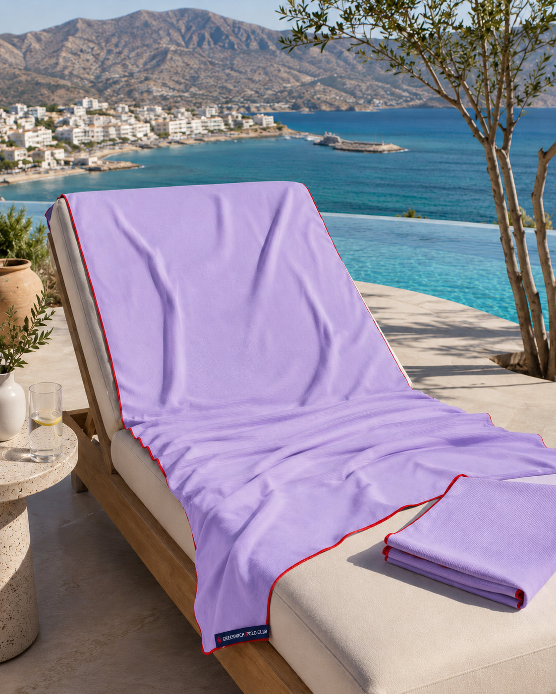 Greenwich Polo Club microfiber beach towel 5231 in lavender with red trim on sunbed overlooking Sitia bay Crete, available at VVC SHOP Sitia and viktoria-vigh.com