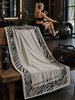 Greenwich Polo Club zebra luxury towel in modern gym with athletic woman using water rower in background 3885