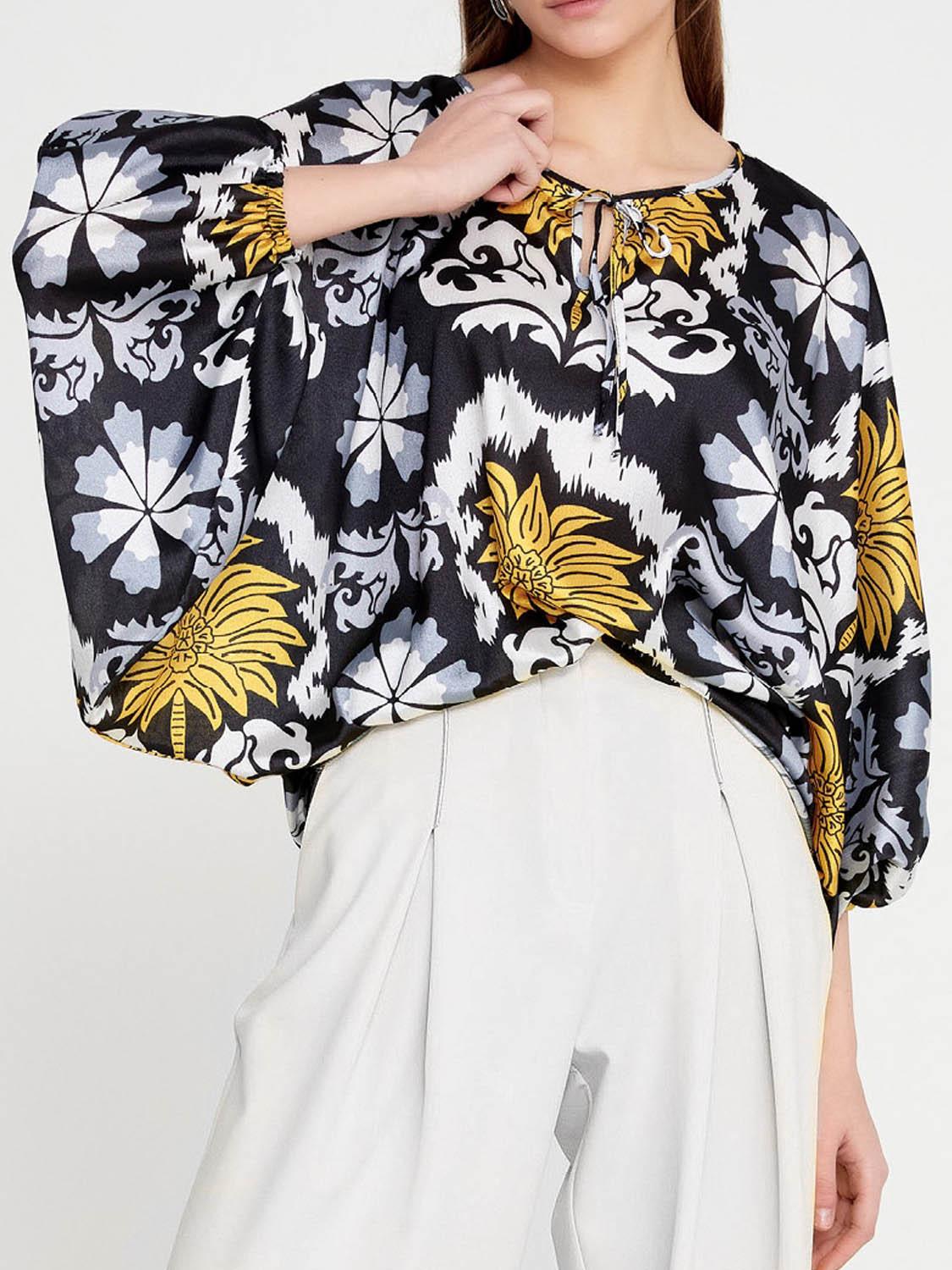 Close-up of Imza black yellow palm tree blouse with tie neckline, batwing sleeves, cuff endings and graphic summer print