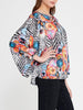 Front view of Imza loose fit zebra floral blouse with black and white animal print, orange flowers and turquoise poppy details