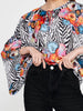 Close-up of Imza zebra floral blouse with tie neckline, black and white zebra pattern, colourful flowers and wide batwing sleeves