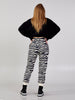 Full-length back view of a model wearing Kasha beige-and-black zebra-print cotton-blend jogger pants with a black top.