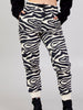 Full-length front view of a model wearing Kasha beige-and-black zebra-print cotton-blend jogger pants with a black top.