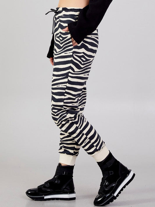 Side view of the Kasha beige-and-black zebra-print jogger pants showing their tapered legs and elastic ankle cuffs.