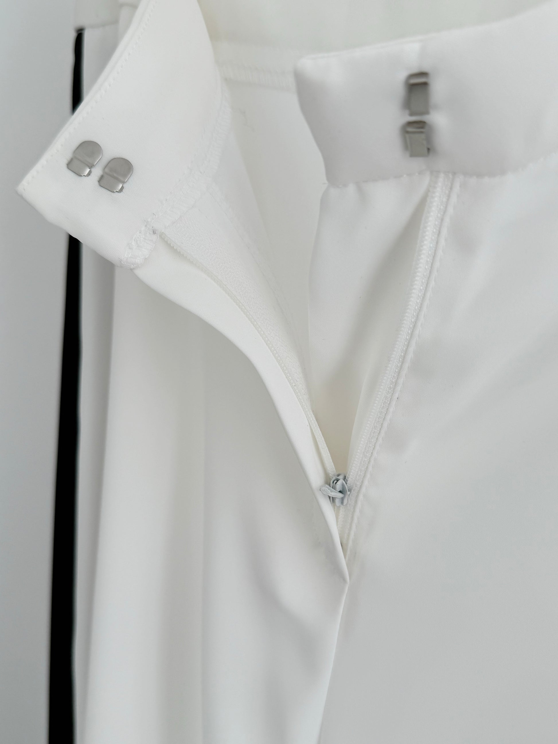 Detail view of Kasha Marlene trousers with hidden zip, discreet hook fastening, lined interior and premium flowing fabric