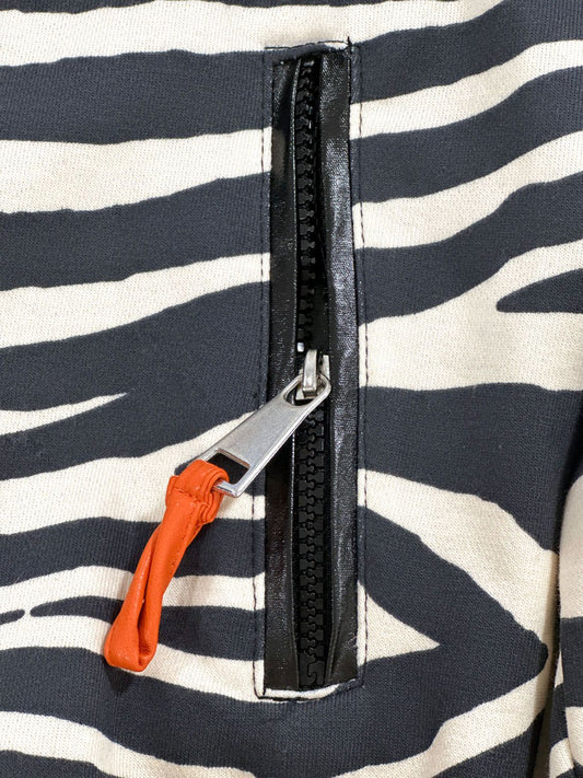 Close-up of the Kasha zebra bomber jacket zip pocket with black trim and orange pull detail