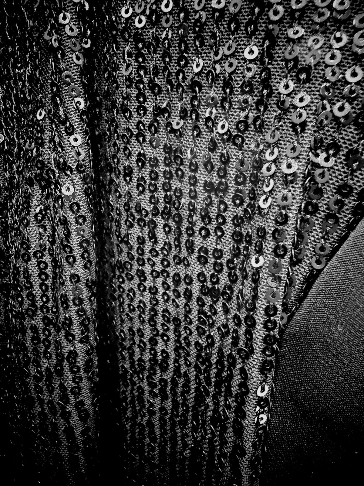 Close-up of the black sequined fabric and textured finish of the Kenco long blazer.