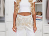 Close-up Women’s laminated gold trousers with white abstract shimmer, casual fit and relaxed silhouette at VVC SHOP Sitia