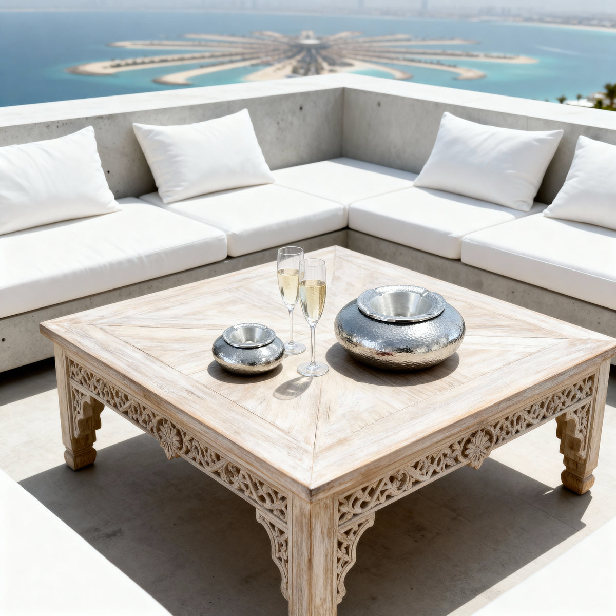 Large silver aluminium ashtray displayed on a Mediterranean terrace table overlooking the sea in Crete.