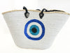 Large white sequin beach basket with blue evil eye motif, black handles and natural straw trim.