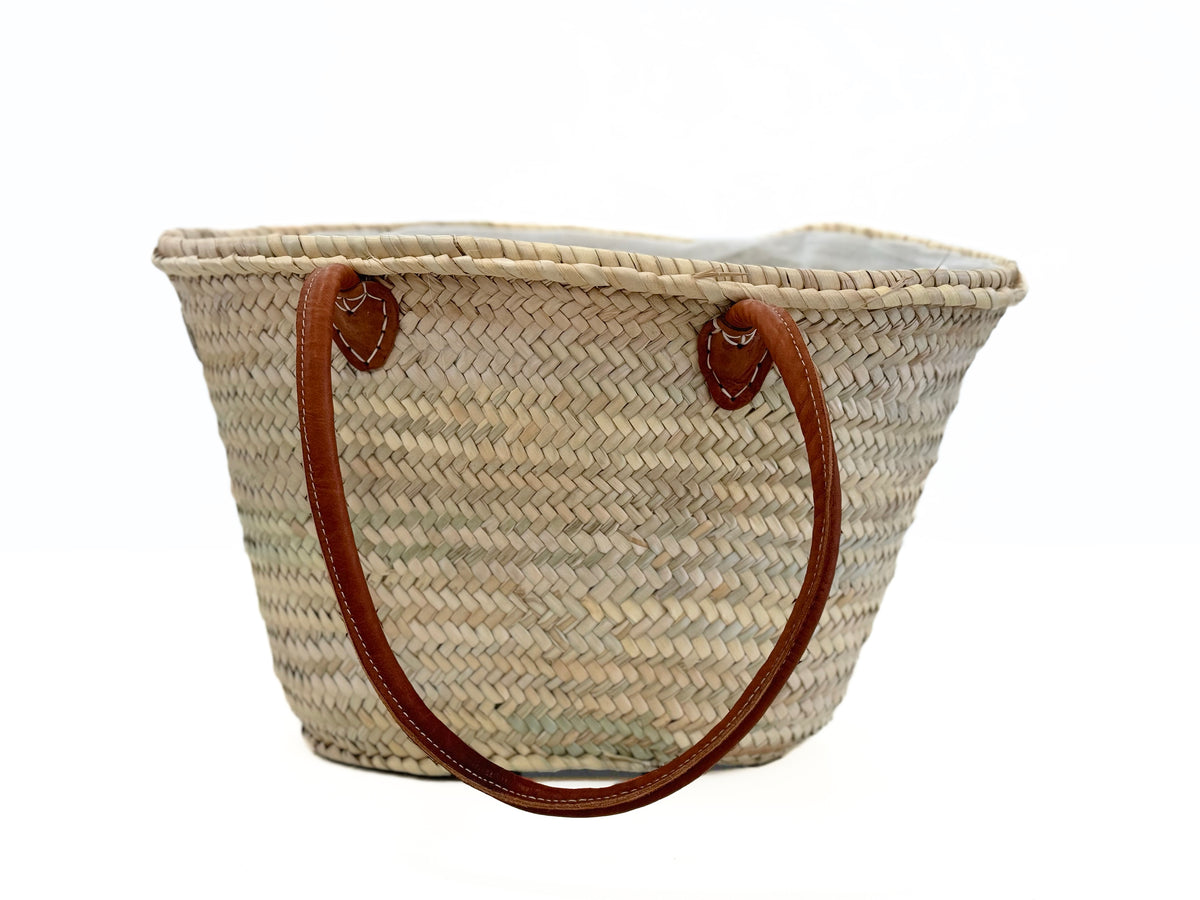 Close-up of large straw basket with brown leather handles tote bag VVC SHOP SITIA