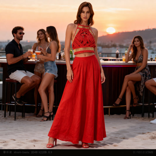 Woman wearing the Melody red macramé top with gold embellishments and a matching red maxi skirt at an evening event in Sitia.