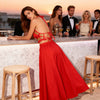 Rear-side view of the Melody red macramé top showing its tied neckline and open-back design with a red maxi skirt.