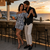 MiandMi black and white animal print viscose shorts jumpsuit worn while dancing at golden hour in Mochlos, Crete, clearly showing the cold-shoulder sleeves and spaghetti straps.