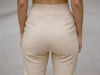 Close-up back view of off white slim fit wool trousers highlighting elastic waistband